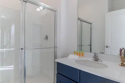a bathroom with a glass shower and a sink at Sophisticated 9 bedroom close to Disney in Kissimmee