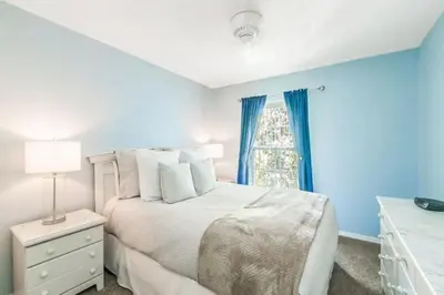 a bedroom with a white bed and a window at Flash 20 Off Townhome at Emerald Island Resort in Kissimmee