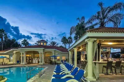 a resort with a pool and lounge chairs at Flash 20 Off Townhome at Emerald Island Resort in Kissimmee