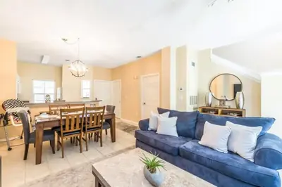 a living room with a blue couch and a dining room at Flash 20 Off Townhome at Emerald Island Resort in Kissimmee