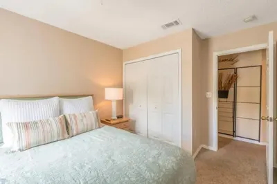 a bedroom with a large bed and a closet at Flash 20 Off Townhome at Emerald Island Resort in Kissimmee