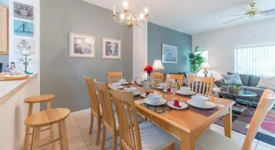 a dining room and living room with a table and chairs at Flash 20 Off Townhome at Emerald Island in Kissimmee