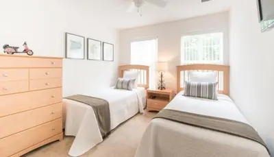 a bedroom with two beds and a dresser at Flash 20 Off Townhome at Emerald Island in Kissimmee
