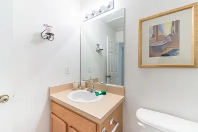 a bathroom with a sink and a mirror at Flash 20 Off Townhome at Emerald Island in Kissimmee