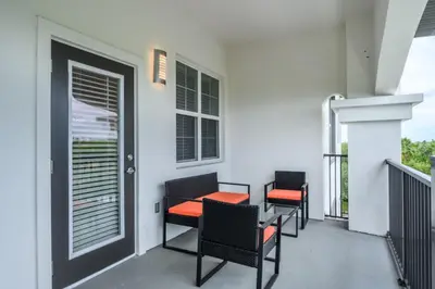 a balcony with three chairs and a table on it at Epic Universe New Modern Vista Cay Reserve Condo - 5007 in Orlando