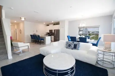 a living room with a white couch and a table at Flash 20 Sale Pvt Pool Townhome at Storey Lake in Kissimmee