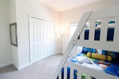 a white bedroom with a bunk bed and a white door at Flash 20 Sale Pvt Pool Townhome at Storey Lake in Kissimmee