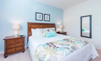 a bedroom with a bed and a dresser and a mirror at Special Offer Elegant Townhome at West Lucaya in Kissimmee