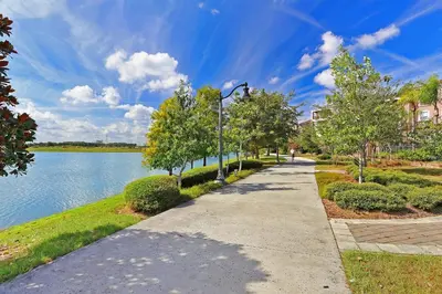 a sidewalk next to a lake with a street light at Brand New Modern Vista Cay Reserve Condo - 5003 in Orlando