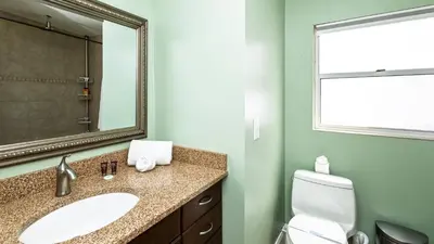 a bathroom with a sink and a toilet and a mirror at Lakefront Retreat - Boat - Fish - Close to all Orlando Parks - Disney - Universal - SeaWorld in Orlando