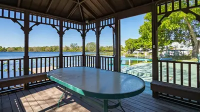 a screened in porch with a table and a view of the water at Lakefront Retreat - Boat - Fish - Close to all Orlando Parks - Disney - Universal - SeaWorld in Orlando