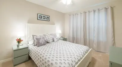 a white bedroom with a bed and a window at Special Offer Cozy Retreat at Compass Bay in Kissimmee
