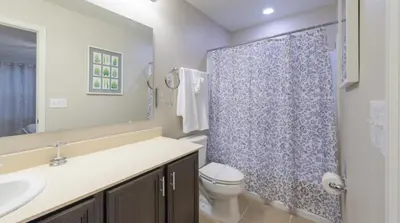 a bathroom with a toilet and a sink and a shower at Special Offer Cozy Retreat at Compass Bay in Kissimmee