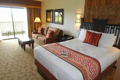 a hotel room with a large bed and a couch at Disney's Animal Kingdom Villas - Kidani Village in Orlando