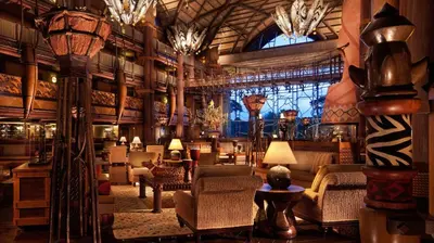 a lobby of a hotel with chairs and chandeliers at Disney's Animal Kingdom Villas - Kidani Village in Orlando