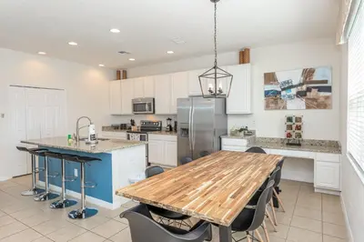 a kitchen with a wooden table and a refrigerator at Special Offer Fantastic Townhome with Pvt Pool and Lake view near Disney in Kissimmee