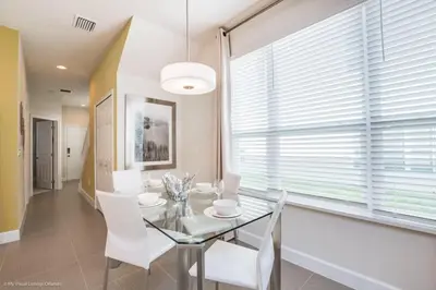 a dining room with a glass table and white chairs at Special Offer Luxury Retreat with Pool in Orlando