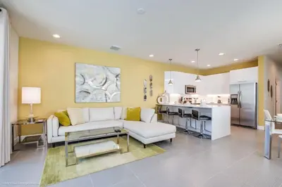 a living room with a white couch and a kitchen at Special Offer Luxury Retreat with Pool in Orlando