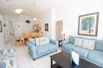 a living room with two blue couches and a table at Special Offer Private Pool Home at Seasons Community in Kissimmee