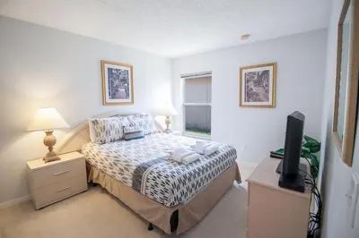 a bedroom with a bed and a television in it at Special Offer Private Pool Home at Seasons Community in Kissimmee