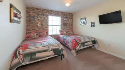 a bedroom with two beds and a flat screen tv at Special Offer Pvt Pool Townhome in Kissimmee