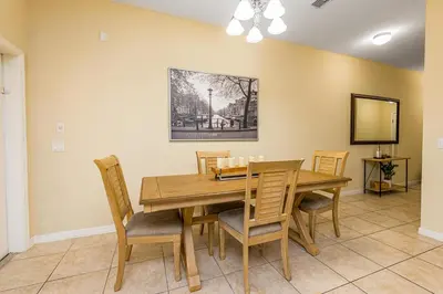 a dining room with a wooden table and chairs at Special Offer Stunning TownHome With Private Pool close to Disney 8960PP in Kissimmee