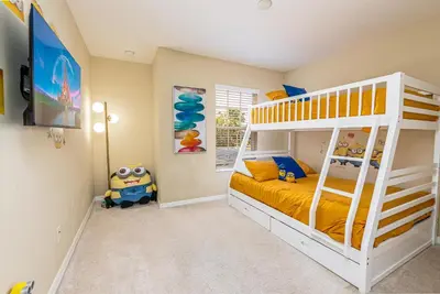 a childs bedroom with a bunk bed with yellow sheets at Special Offer Stunning TownHome With Private Pool close to Disney 8960PP in Kissimmee