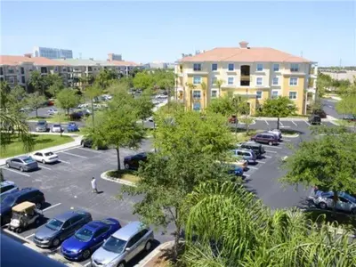 a parking lot with cars parked in front of a building at Special Offer Stylish Apartment at Vista Cay Resort in Orlando