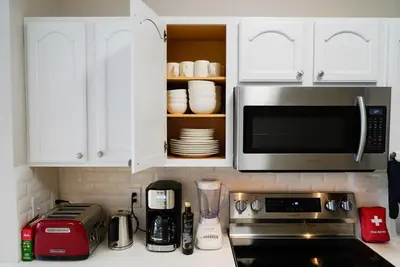 a kitchen with white cabinets and a microwave at New Luxury Disney Townhome at Windsor Hills Resort, 3BED 3BATH, Private Pool Parking WiFi Included in Orlando