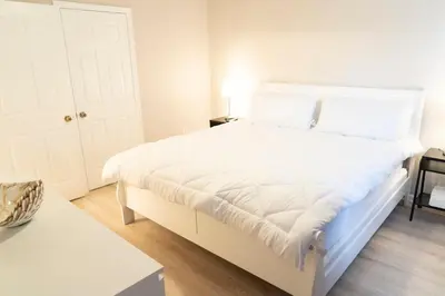 a large white bed in a room with a table at New Luxury Disney Townhome at Windsor Hills Resort, 3BED 3BATH, Private Pool Parking WiFi Included in Orlando