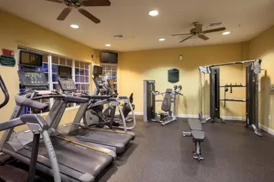 a gym with several treadmills and cardio machines at Special Offer Stylish Apartment at Vista Cay in Orlando