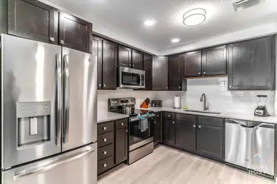 a kitchen with stainless steel appliances and wooden cabinets at Special Offer Stylish Apartment at Vista Cay in Orlando