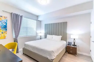 a bedroom with a bed and a desk and a window at Stylish Apartment at Vista Cay in Orlando