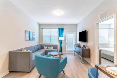 a living room with a blue couch and a bed at Stylish Apartment at Vista Cay in Orlando