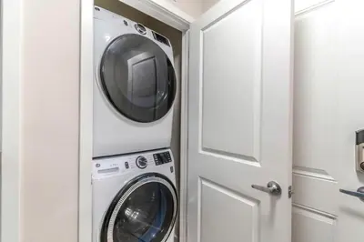 a laundry room with a washer and dryer next to a door at Stylish Apartment at Vista Cay in Orlando