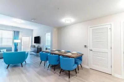 a dining room with a table and blue chairs at Stylish Apartment at Vista Cay in Orlando