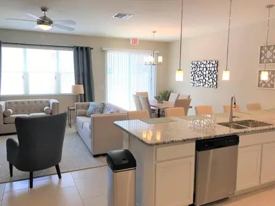 a living room with a kitchen and a living room with a couch at Special Offer Townhome at Compass Bay in Kissimmee