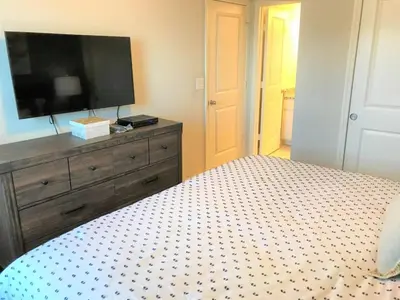 a bedroom with a bed with a tv and a dresser at Special Offer Townhome at Compass Bay in Kissimmee
