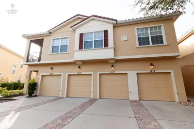 a house with four garage doors in a driveway at Special Offer Townhome at Oakwater Resort in Orlando