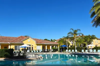 a pool at a resort with chairs and umbrellas at Special Offer Townhome at Oakwater Resort in Orlando