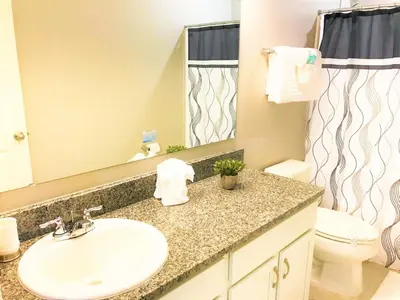 a bathroom with a sink and a toilet and a mirror at TVPM5150CHCB in Kissimmee