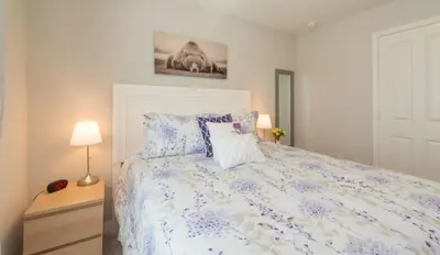 a bedroom with a large bed with purple flowers at TVPM5164ADCB in Kissimmee