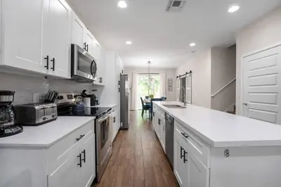a kitchen with white cabinets and white counter tops at New Listing - Modern decoration 4 BR Townhouse in Kissimmee