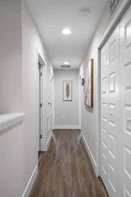 a hallway with white walls and white doors and wood floors at New Listing - Modern decoration 4 BR Townhouse in Kissimmee
