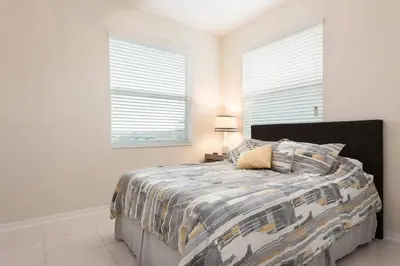 a bedroom with a bed and two windows at Aconchegante 3Q no Storey Lake – 10 min da Disney! in Kissimmee