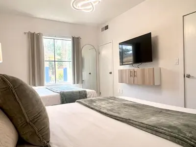 a hotel room with two beds and a tv at Condo close to Epic Universe - free parking in Orlando