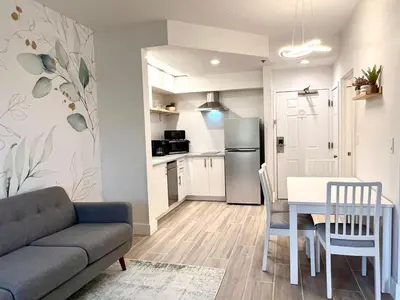 a living room with a couch and a table and a kitchen at Condo close to Epic Universe - free parking in Orlando
