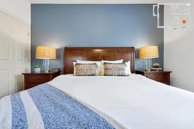 a bedroom with a large white bed with two lamps at Charming Oasis with King Bed Close to Disney 4BR in Kissimmee