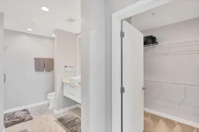 a white bathroom with a shower and a toilet at Modern 3 bedroom condo in downtown w free parking in Orlando