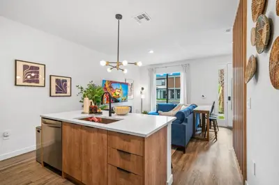 a kitchen with a sink and a living room at Colorful vibrant Oasis Sleeps 10, 10min to Disney in Kissimmee
